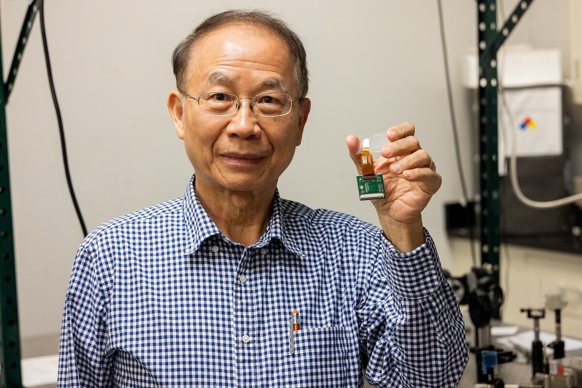 Shin-Tson Wu holds a chip while in his lab