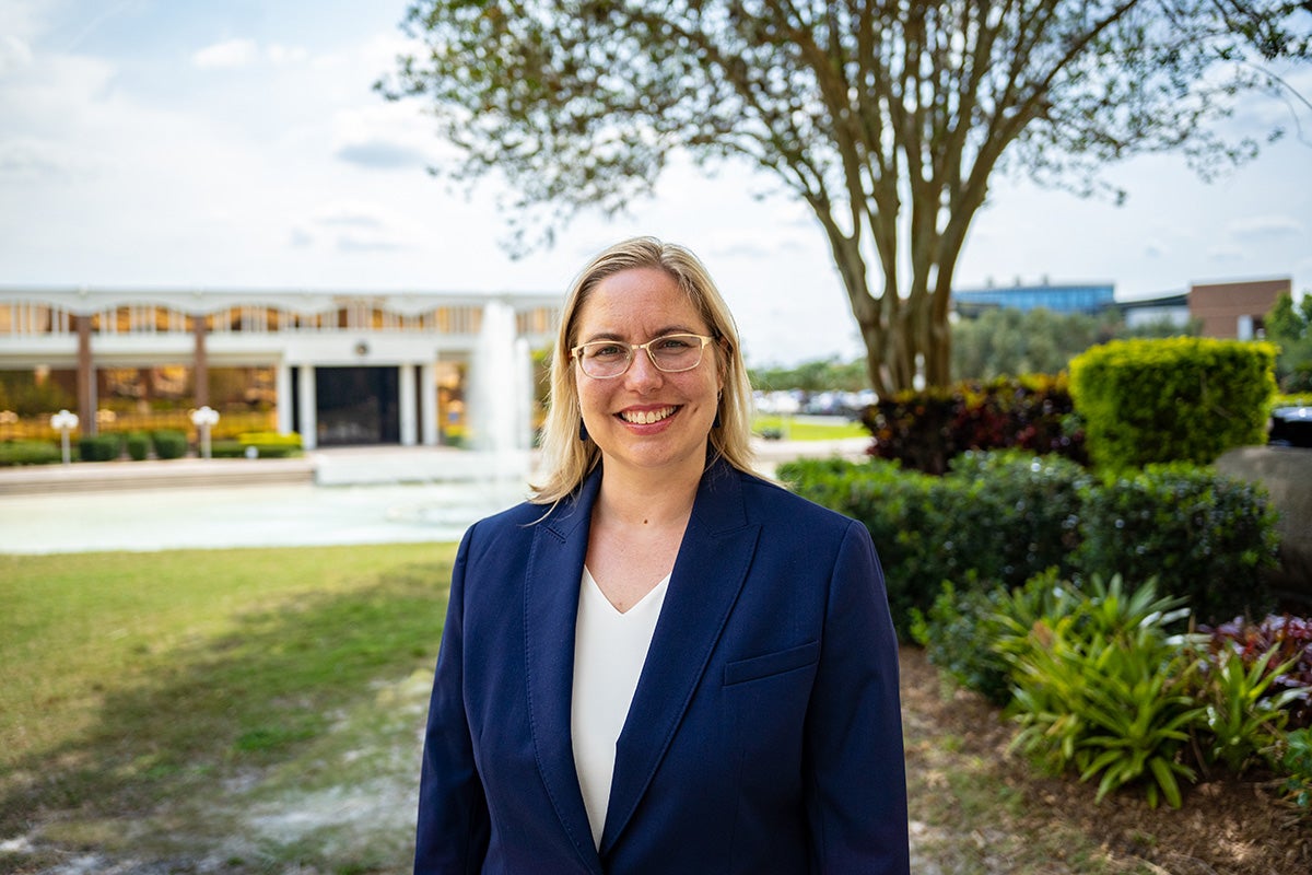 Barbara “Basia” Andraka-Christou stands outside at UCF in front of the reflecting pond.