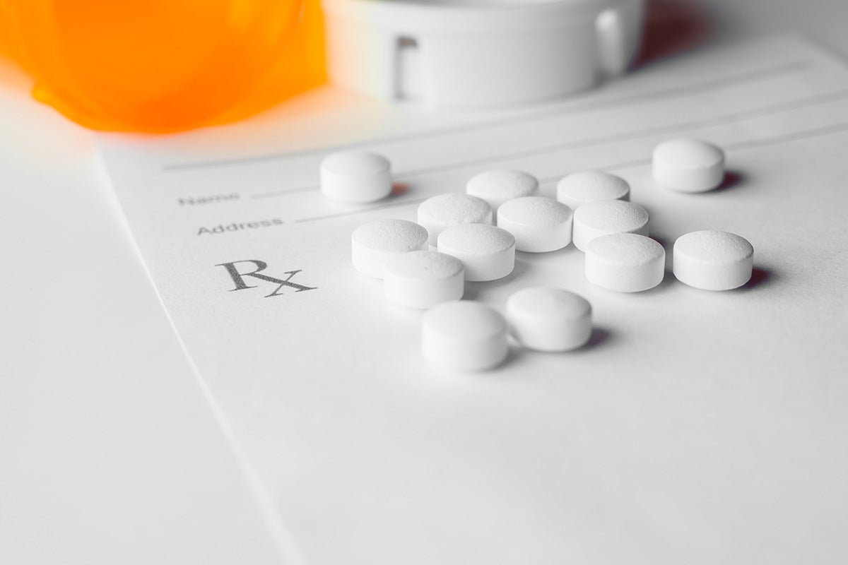 Pills are shown on top of a prescription form.