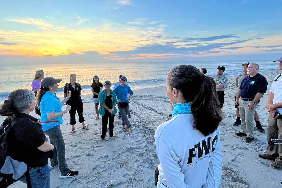 A group of people listen to a speaker talk about sea turtle conservation at Archie Carr National Wildlife Refuge.