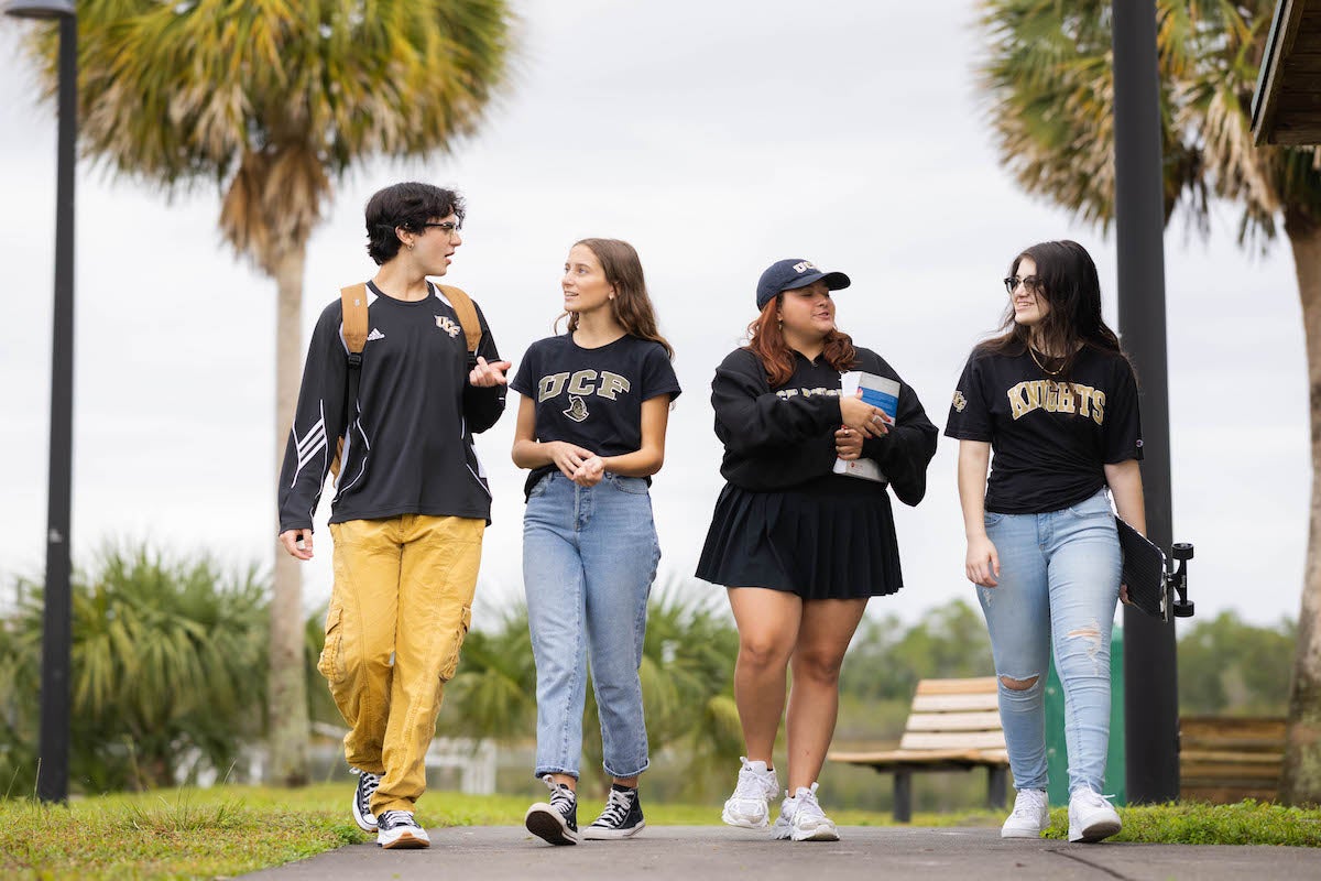 Students walking on UCF's campus while wearing UCF clothing