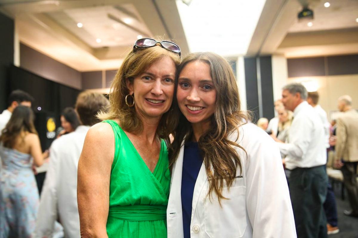 Laurie Borick stands next to her daughter Ellie Boric, who is wearing a white coat, and poses for a photo