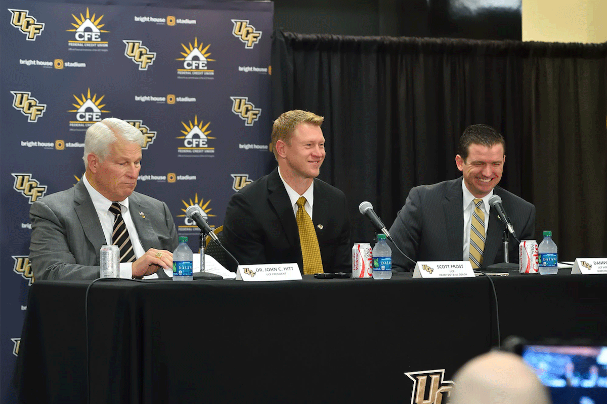 John C. Hitt, Scott Frost and Danny White sitting at a table with mics during a press conference.