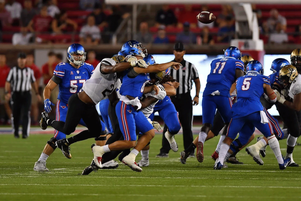 A UCF football player tackles an SMU player