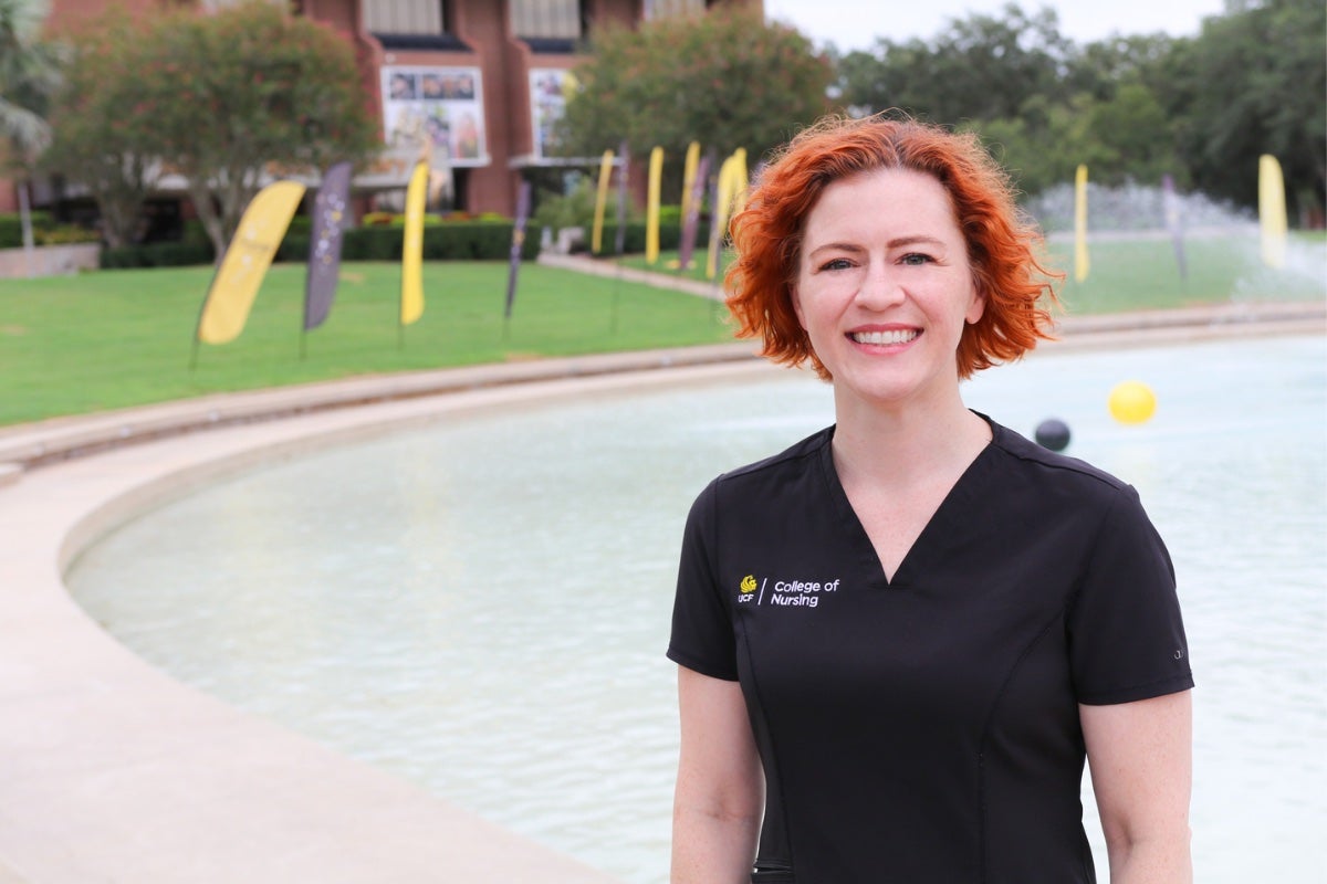Kris Hysler wears nursing scubs while in front of UCF's Reflecting Pond.