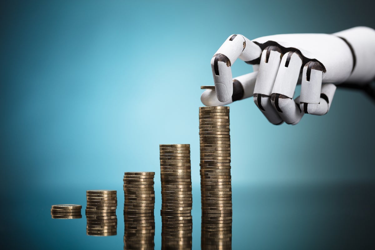 Close-up Of A Robot's Hand Stacking Golden Coins On Turquoise Background