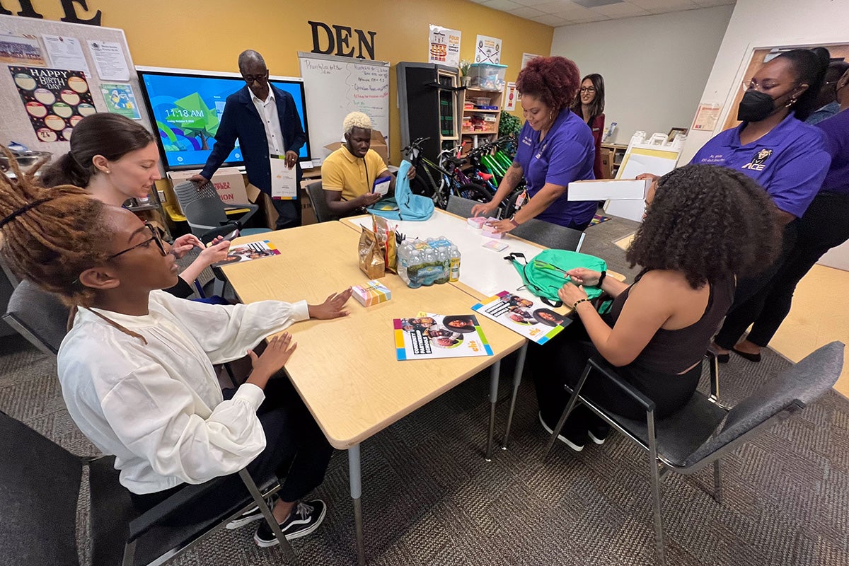 Visiting Duke University and North Carolina Central University students help fill new backpacks for students in need at Orange County Public Schools’ Academic Center for Excellence, a Community Partnership School. Photo by Amy Floyd