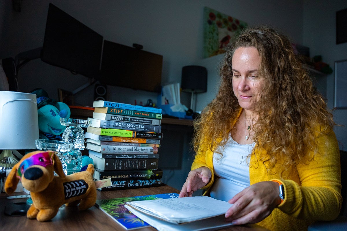 Staci Zavattaro sitting at a desk with a notebook and a stack of books