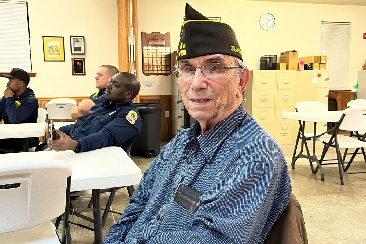 A man wearing a U.S. Navy side cap.