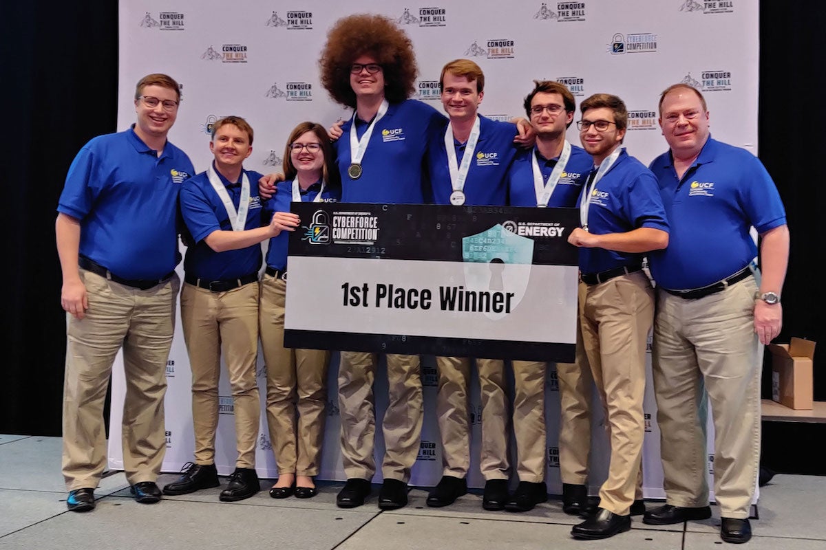 A group of students and a faculty member holding a sign that says "1st Place"