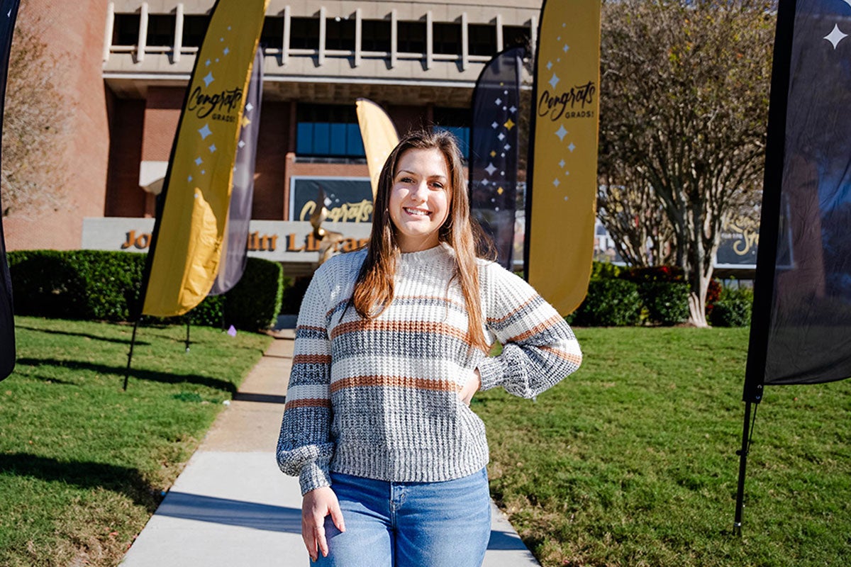 Ashley Ellixson in front of the John C. Hitt Library