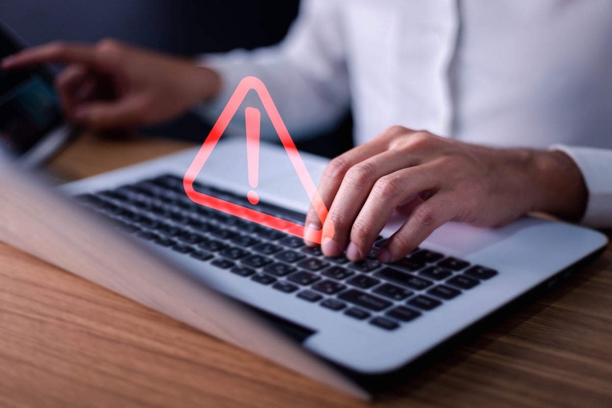 Error and maintenance concept. Businessman or it staff , programmer, developer using computer laptop with triangle caution warning sign for notification .