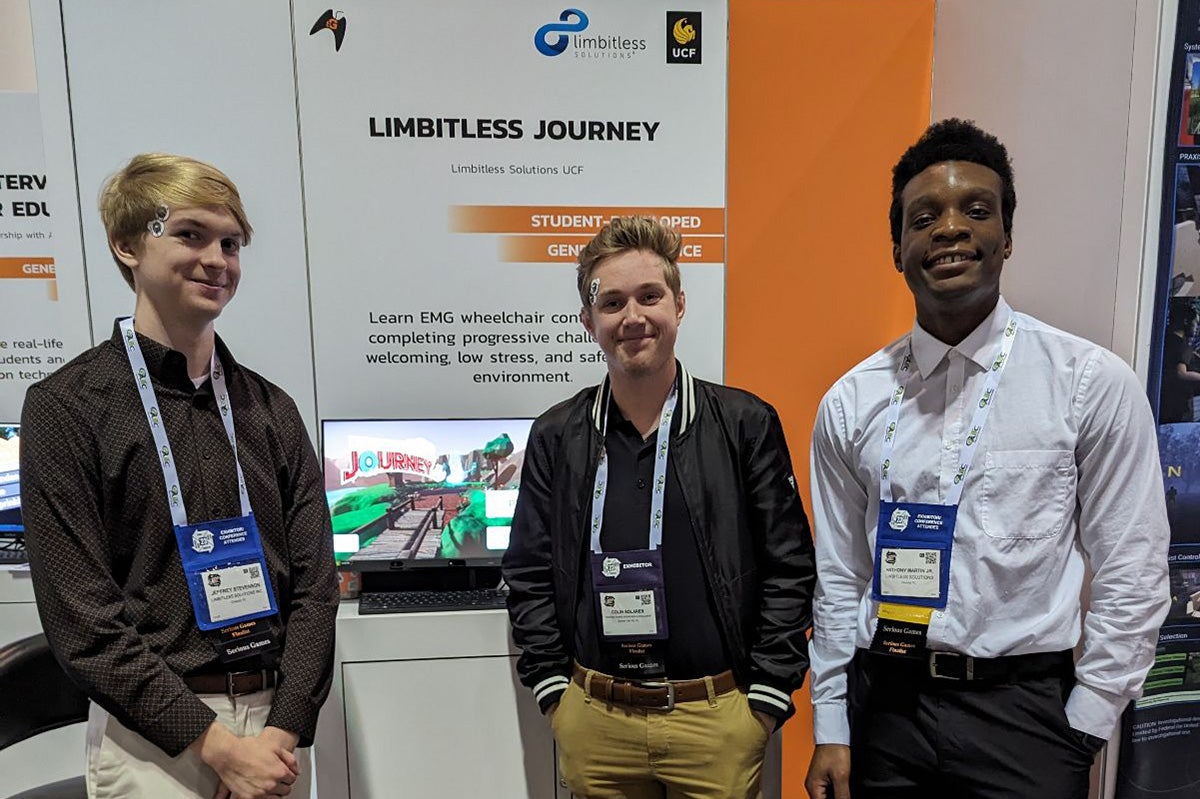 Limbitless Solutions’ UCF student scholars stand in front of their display at I/ITSEC