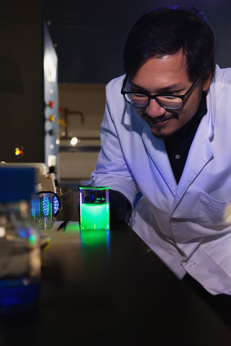 UCF chemistry doctoral student Jorge Pereira observes the fluorescence of an agrochemical formulation, which can be used to assess whether the formulation has systemic activity in plants.