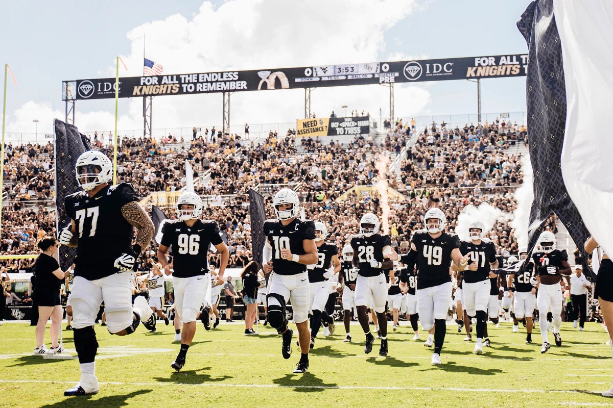 UCF's football team running onto the field