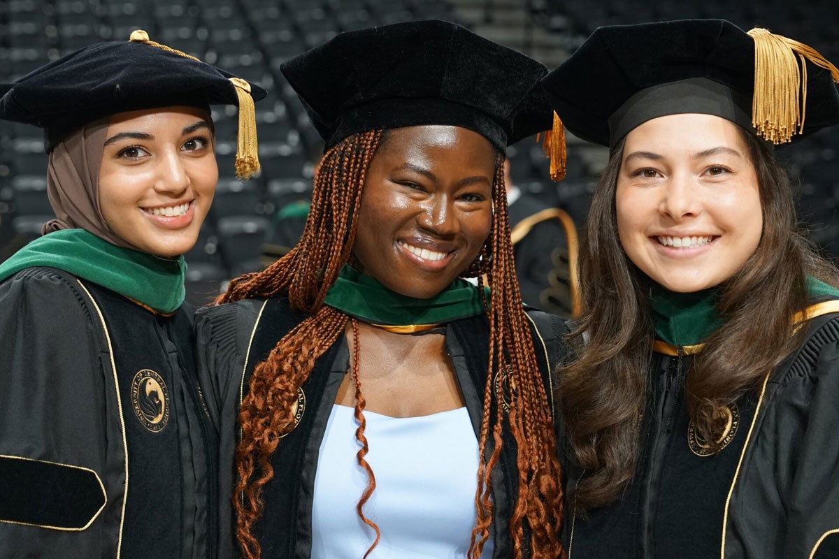 Three graduates wearing regalia