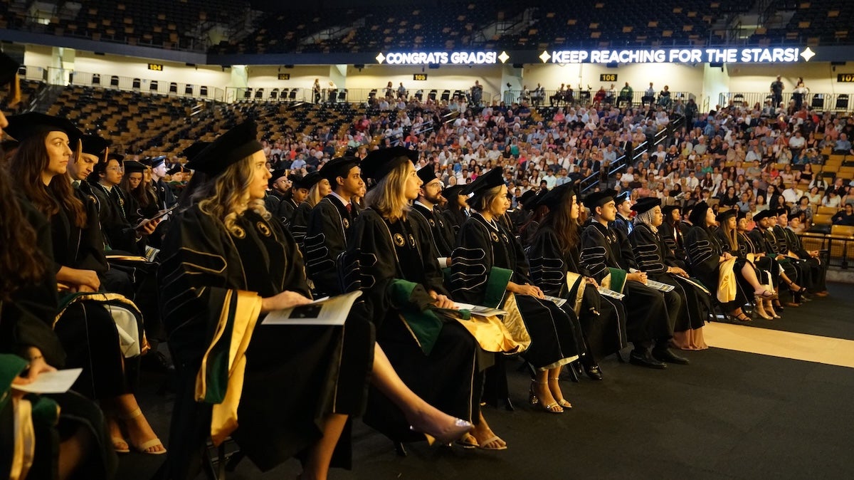 A room full of graduates wearing regalia 