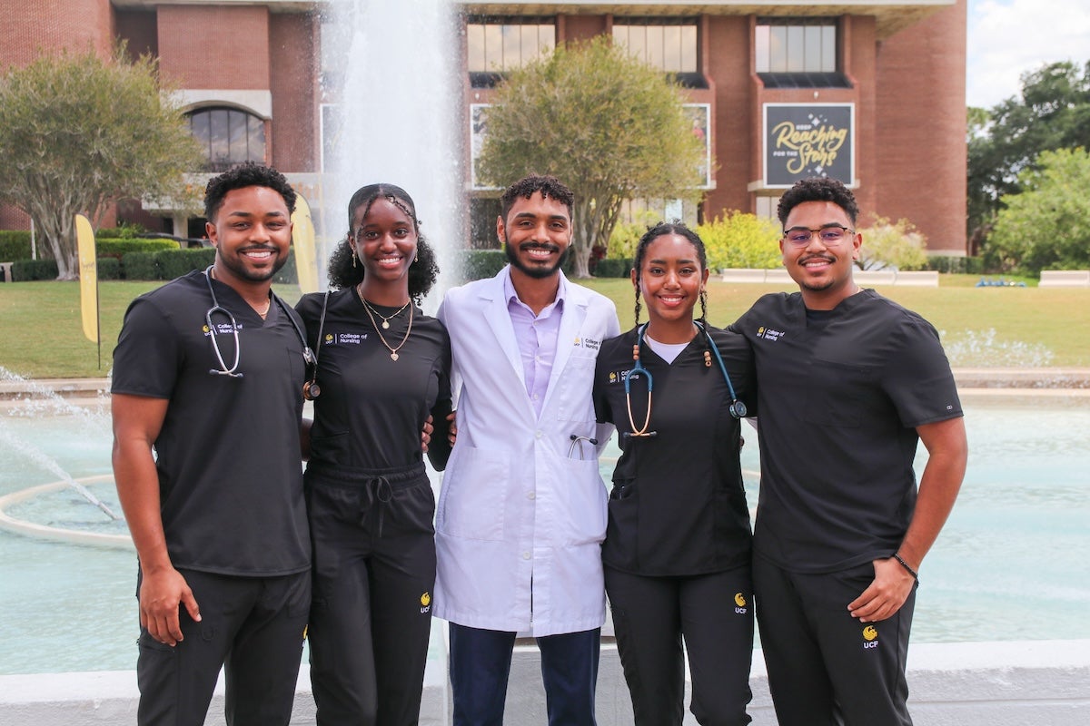 Stephen Frederick, Sulah Monize, David Frederick, Linah Monize, Samuel Frederick if front the Reflecting Pond on UCF's campus