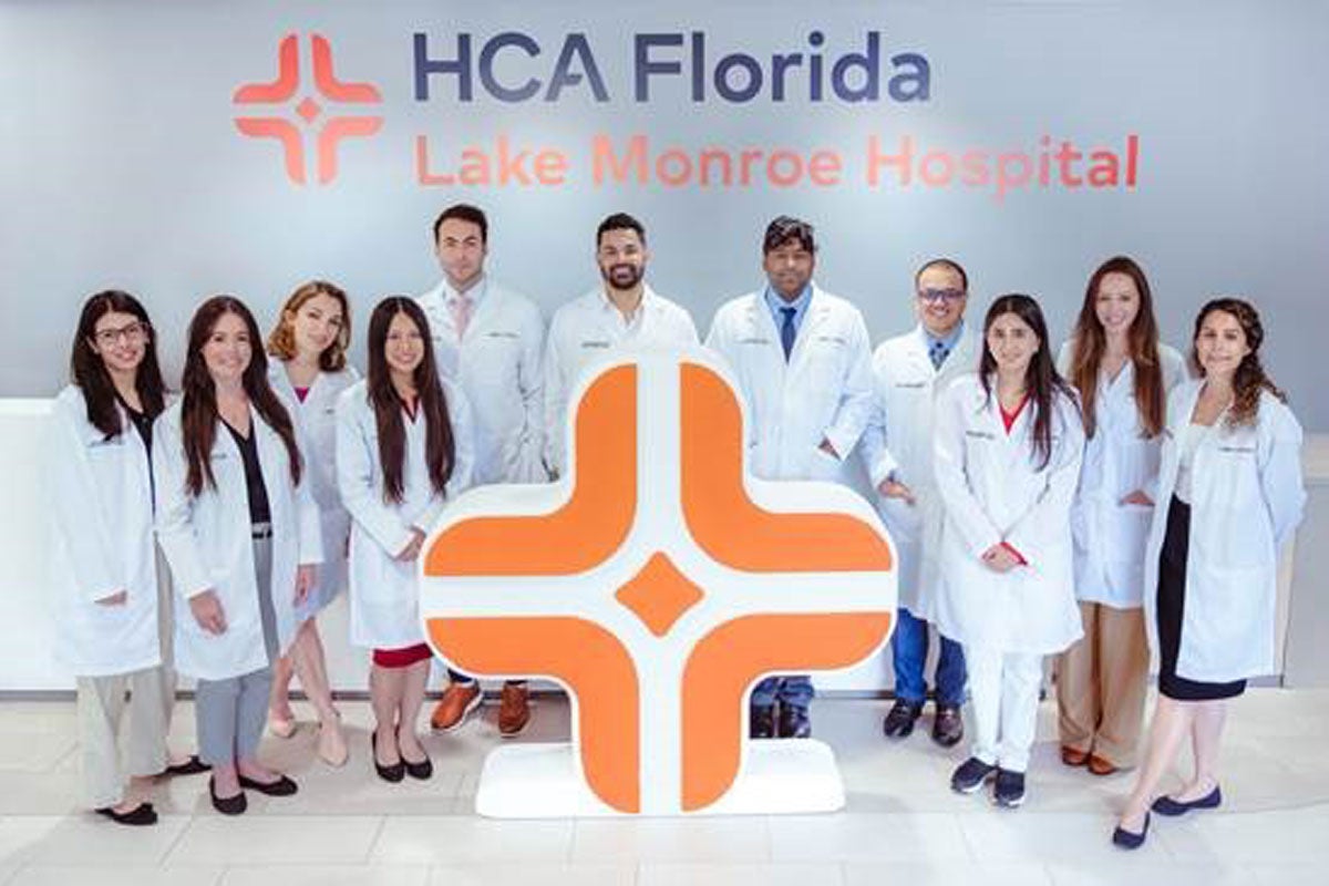 People in white coats posing for a photo under the HCA Florida logo