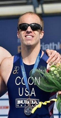 Person in center with glasses and medal