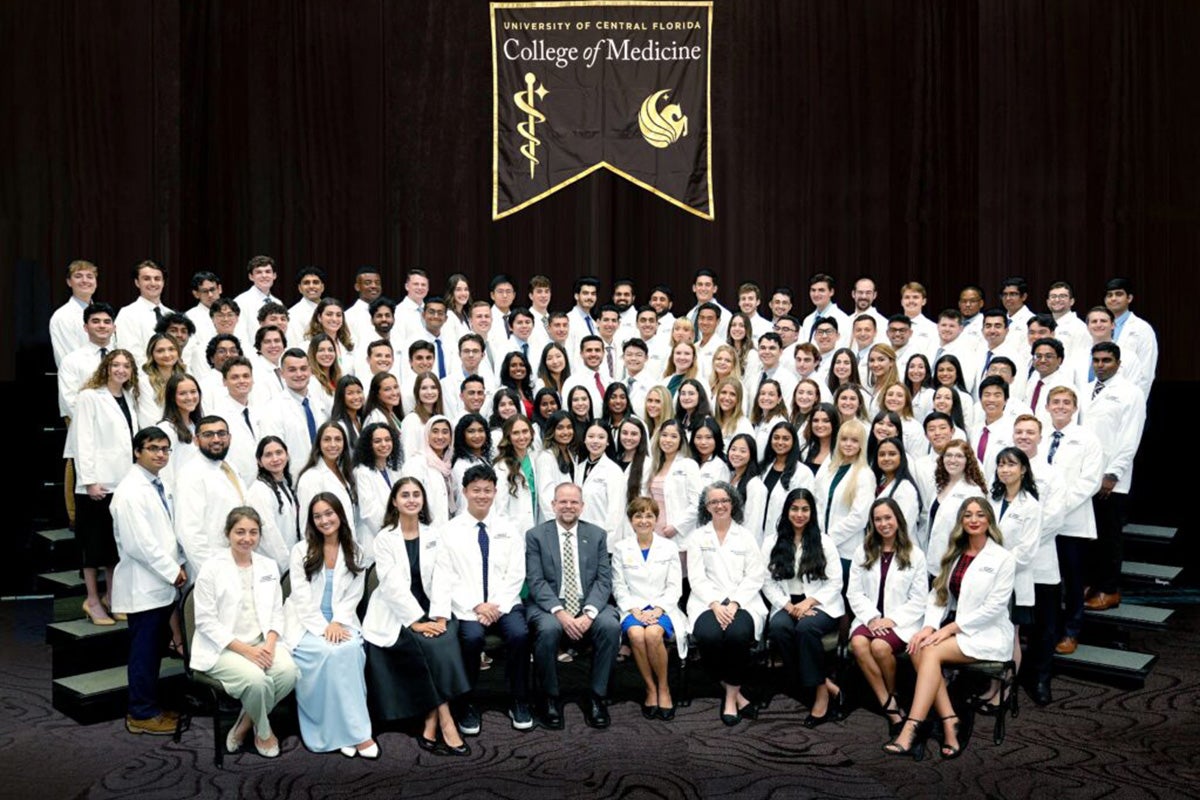 Group of 120 M.D. students pose for a photo during the UCF College of Medicine White Coat Ceremony.