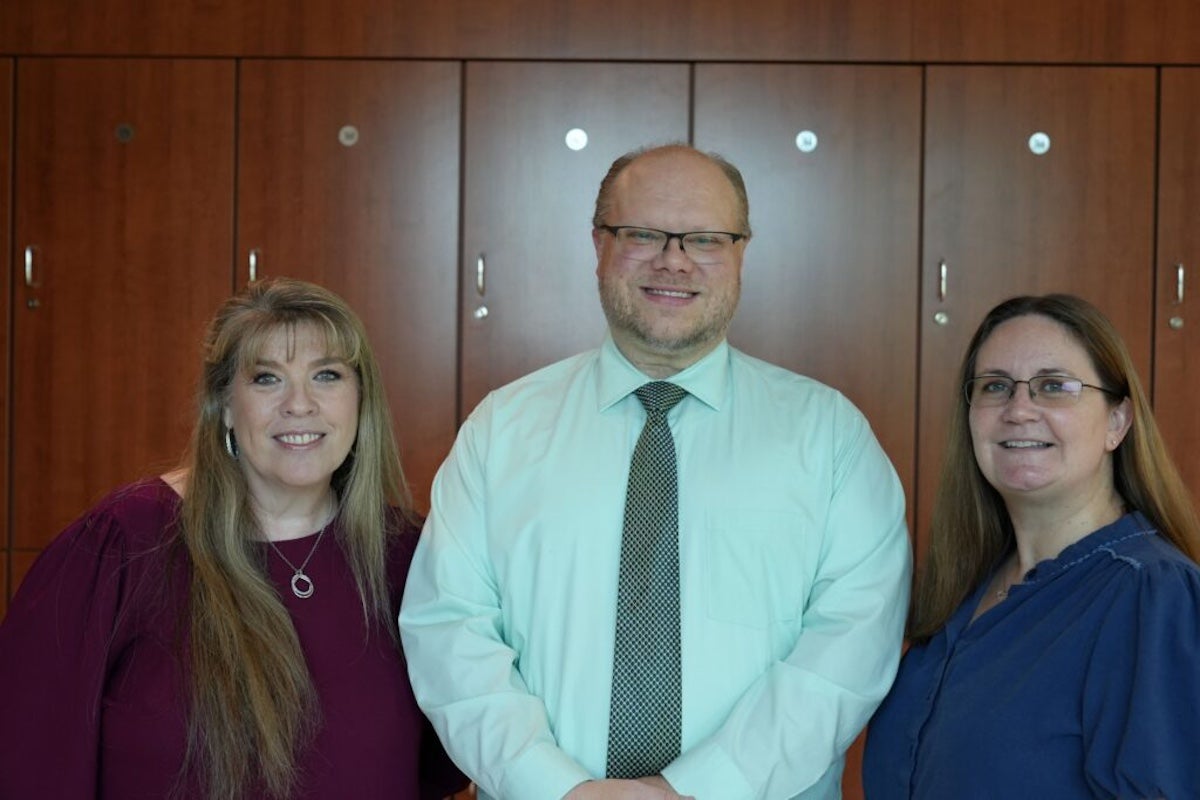 UCF College of Medicine staff members Mary Ann Reiner, Jason Konzelmann and Jennifer Neal pose together for a photo.