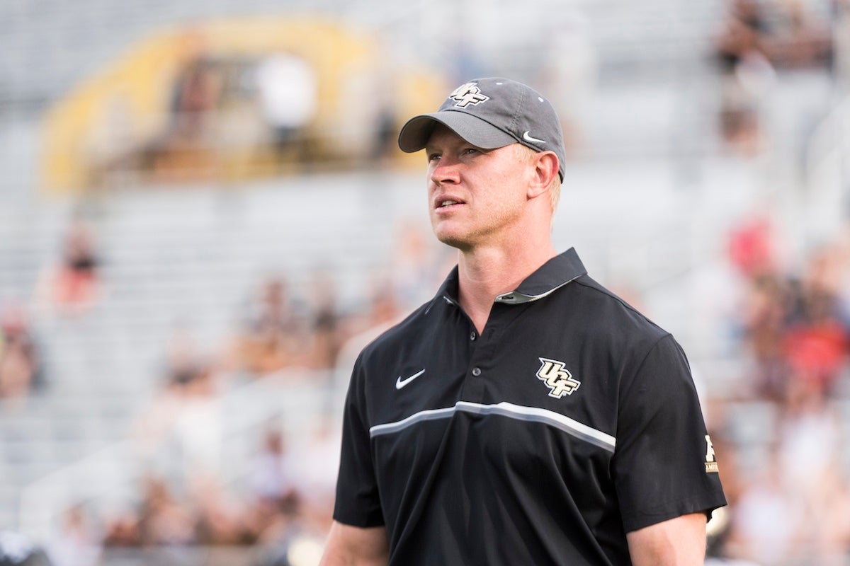 UCF Head Football Coach Scott Frost looking out on a football field