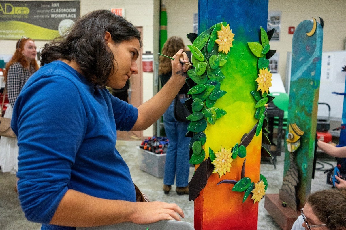 A student painting on a sculpture for the Celebrating Chagall exhibition