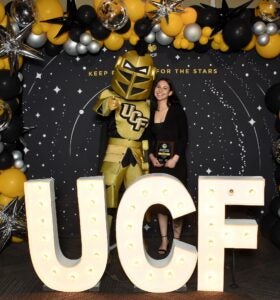 Person standing with Knightro.