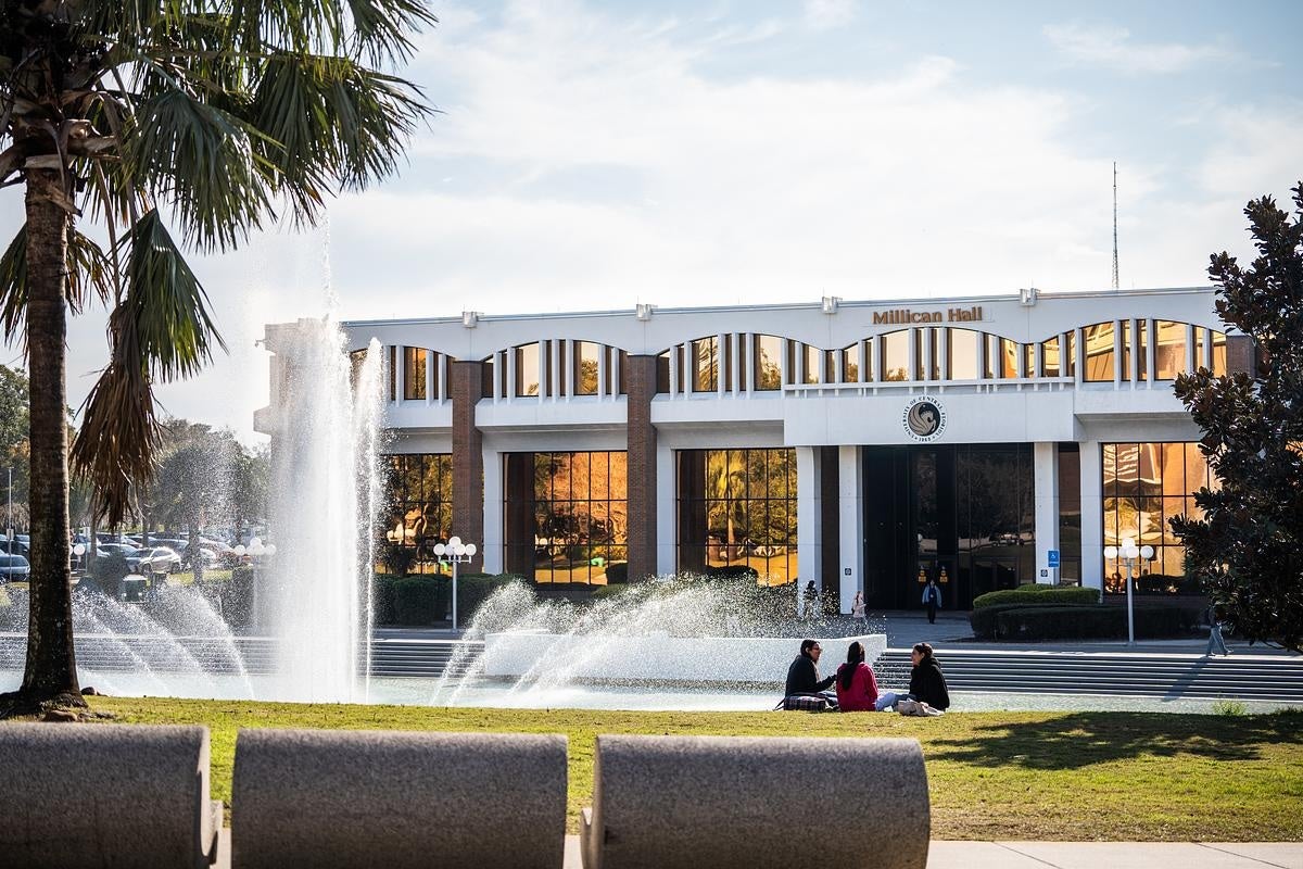 students sitting in front of Millican Hall