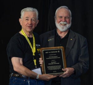 ICPC President, CEO and Board Chair Bill Poucher presents the ICPC Foundation and Jet Brains “Outstanding Contribution Award” to UCF Provost Michael Johnson.