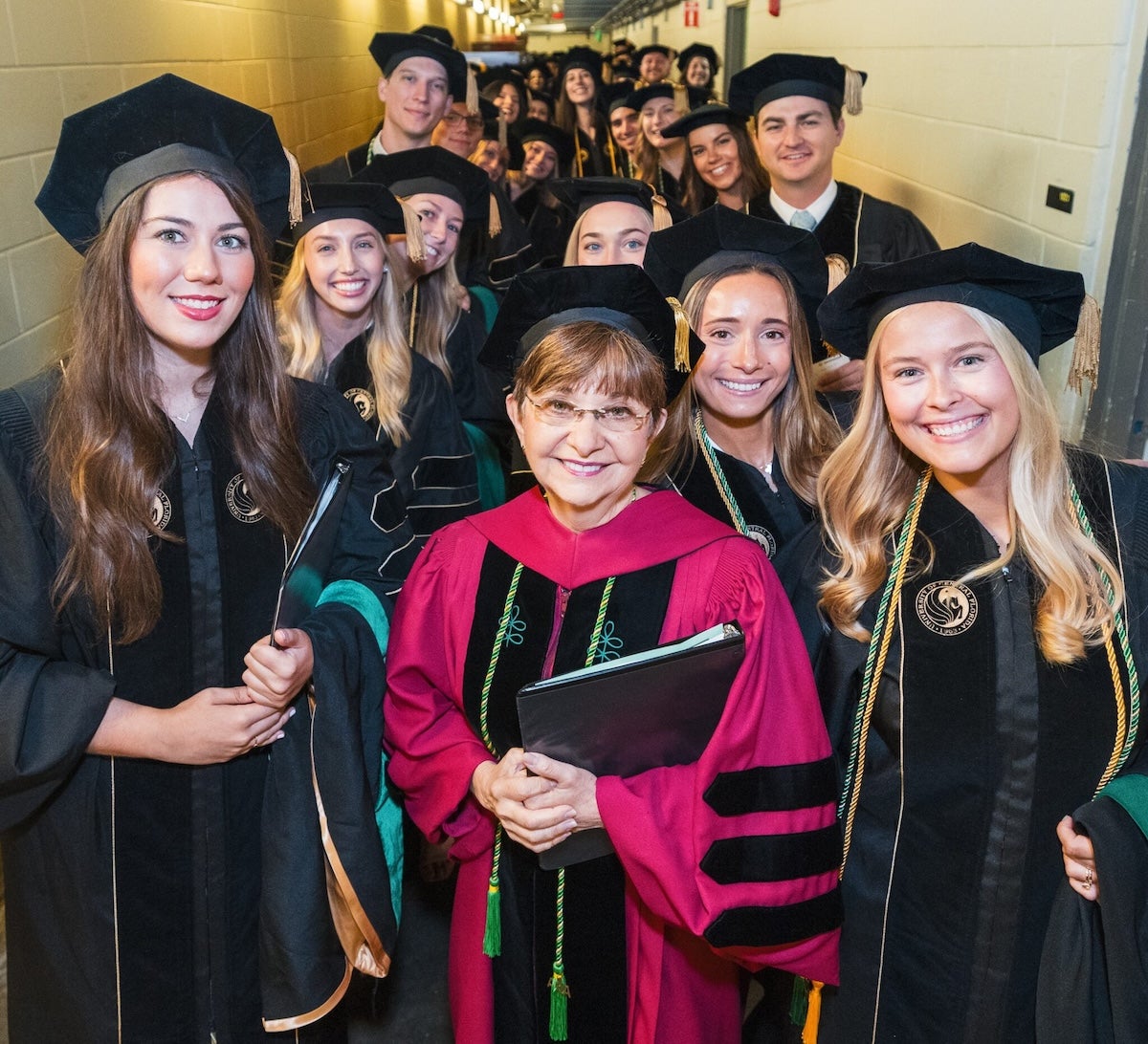 Deborah German and graduates wearing regalia