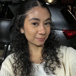 UCF communication sciences and disorders student Stefy Batres smiles slightly while taking a selfie inside of a a parked car.