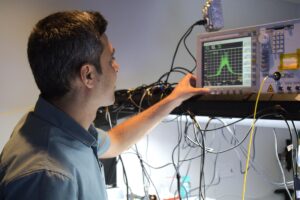 Amin Hashemi Shahraki ’24MS adjusts an optical spectrum analyzer in the lab.