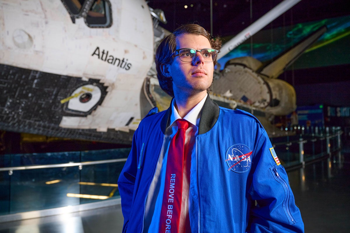 Keanu Brayman posing for a photo in front of the Atlantis spacecraft