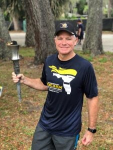 Carl Metzger, UCF’s associate vice president of public safety, holds a torch during the Law Enforcement Torch Run.