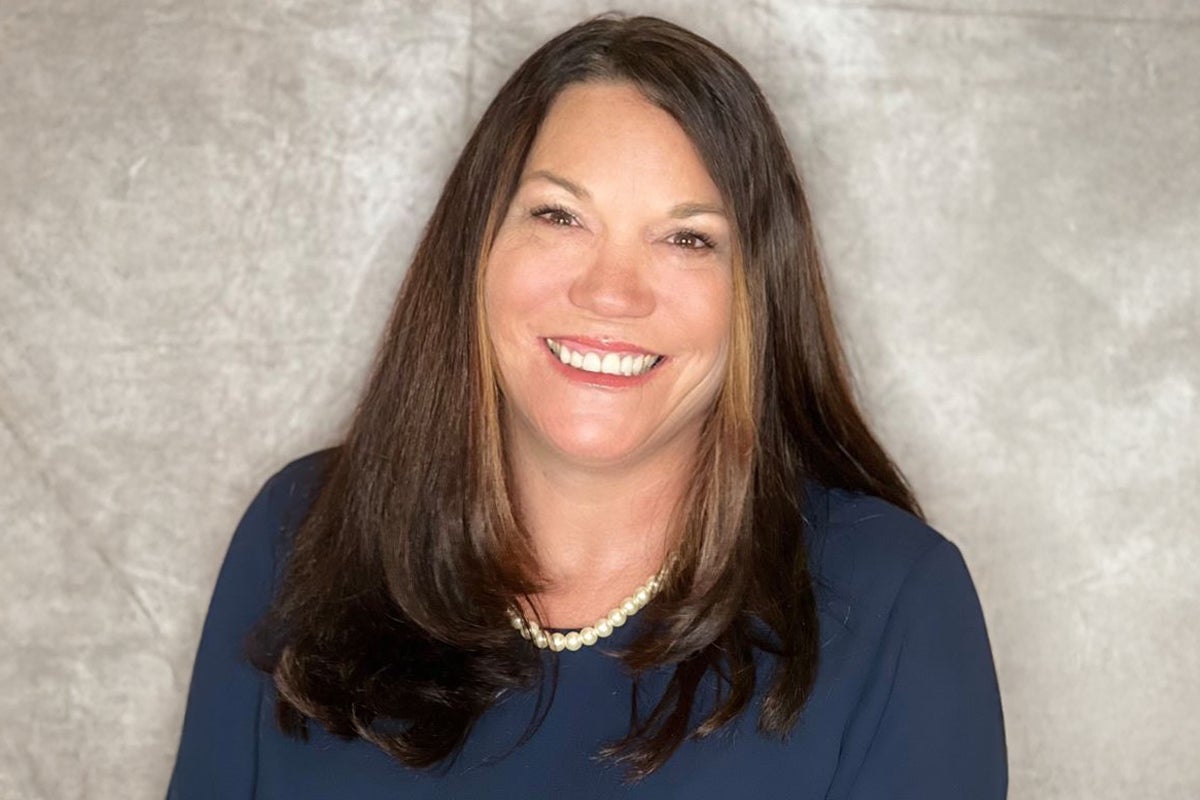 Robin Winder ’92, UCF alum and chief academic officer for Florida Virtual School, smiles for a photo in front of a grey background.