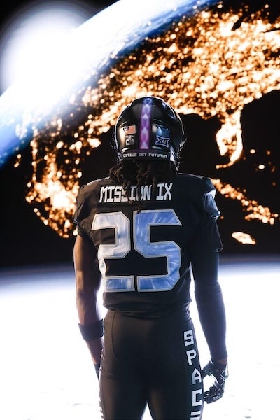 Football player in black uniform with “MISSION IX” and number 25 stands on a moon-like surface with Earth glowing in the background.