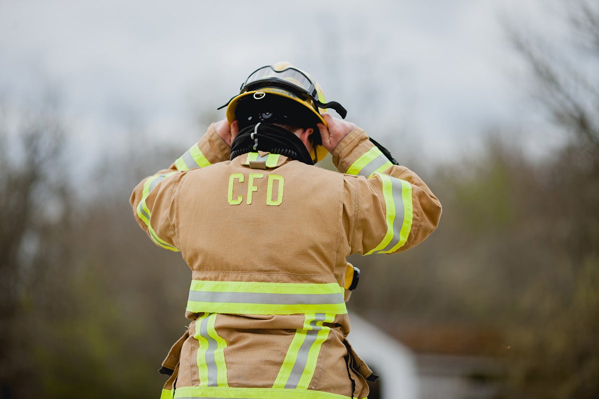 Firefighter adjusts helmet
