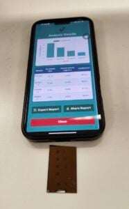 An iPhone lies face up on a table displaying a bar graph on the screen.