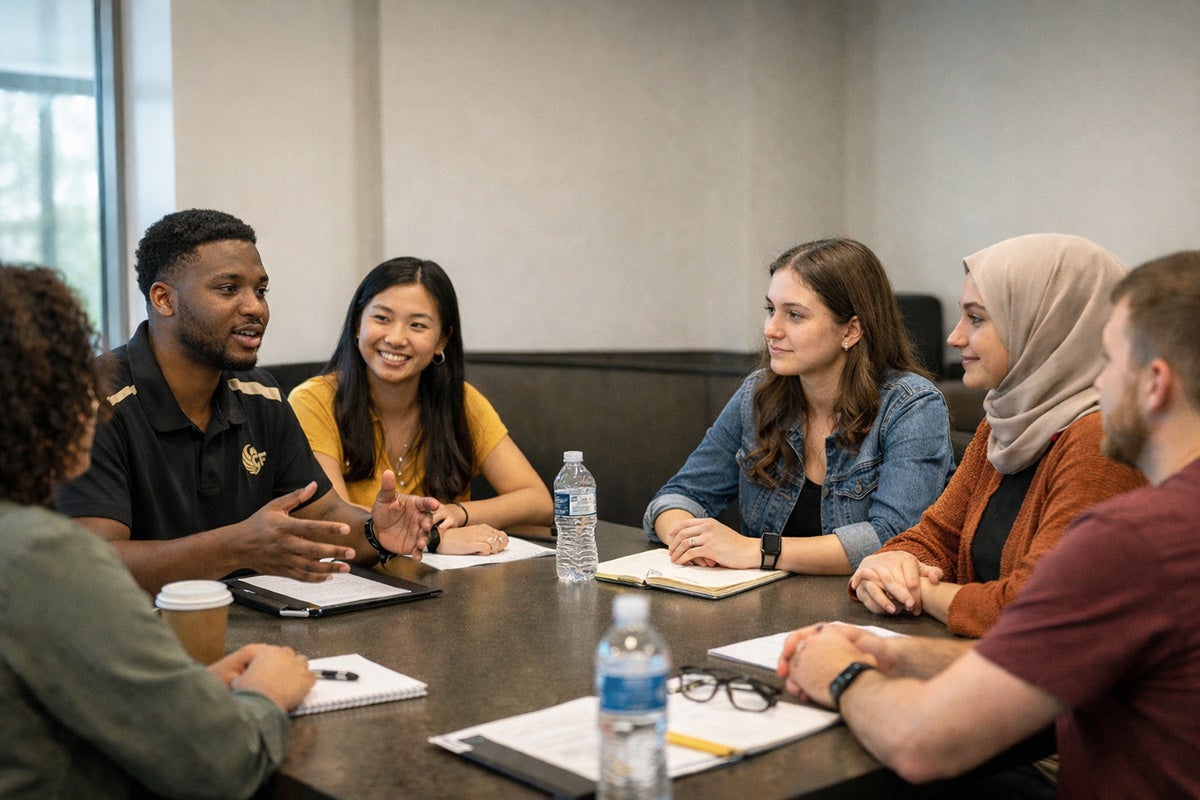 Six male and femal students sit at a round table