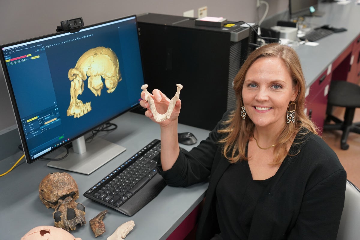 UCF Assistant Professor Sarah Freidline holding a life-size cast of a Homo erectus mandible.