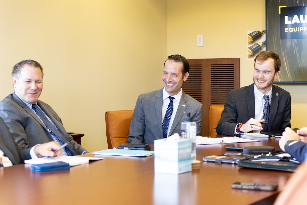 Three people smiling at a table