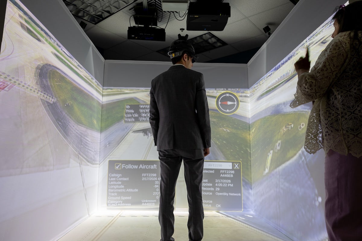 A person wearing a VR headset and standing in a projection studio