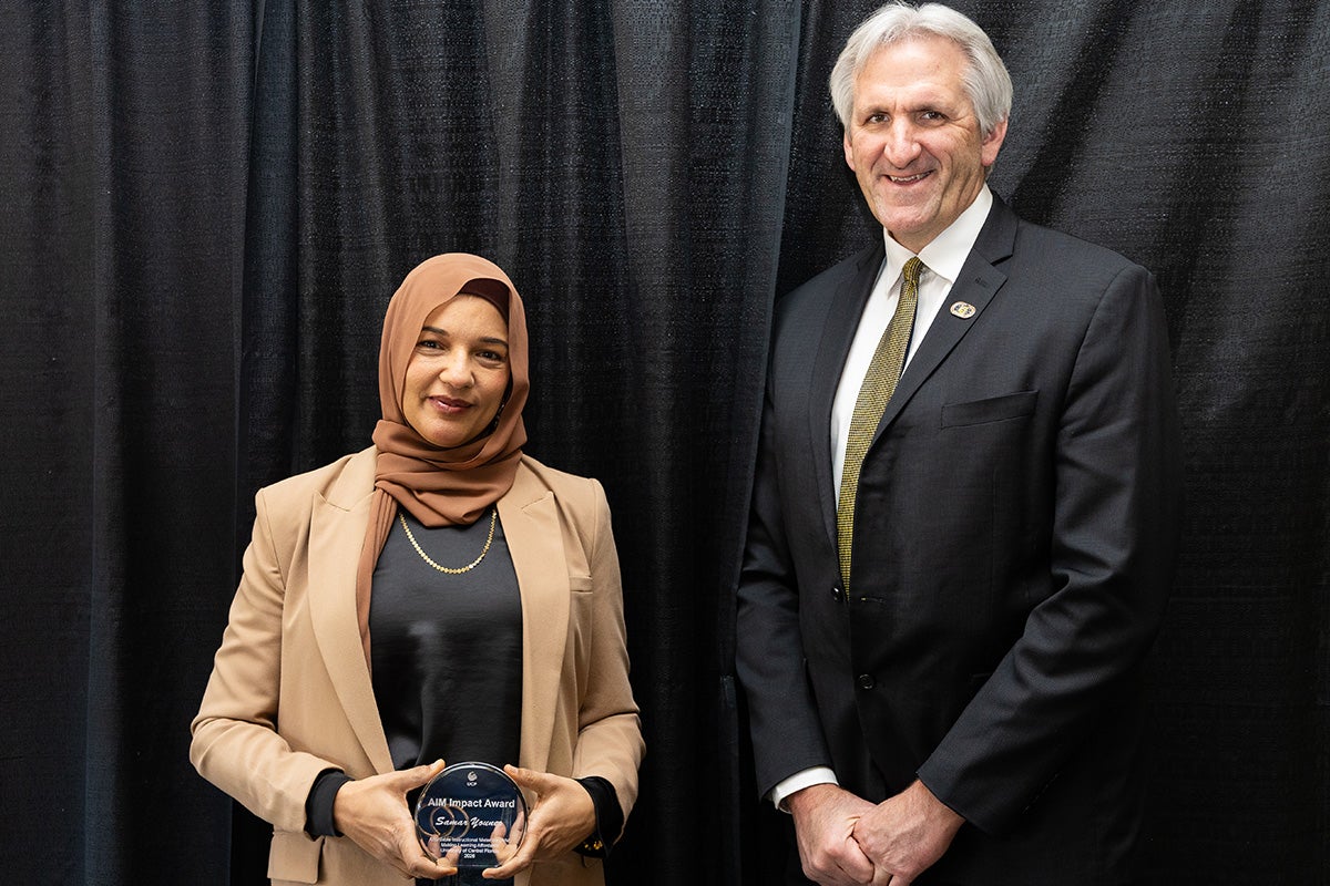 UCF Associate Professor of Engineering Samar Younes and Provost John Buckwalter stand side by side in front of a black backdrop.