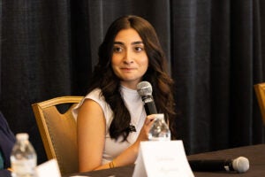 Shivani Vakharia, academic affairs coordinator for UCF’s Student Government Association, sits at a table holding a microphone during a student-faculty panel.