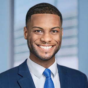 Portrait of smiling man in blue suit with white collar shirt and blue tie