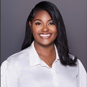Portrait of smiling woman with strait black hair in white collar blouse