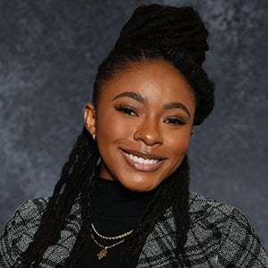 Portrait of smiling woman with black hair in plaid blazer