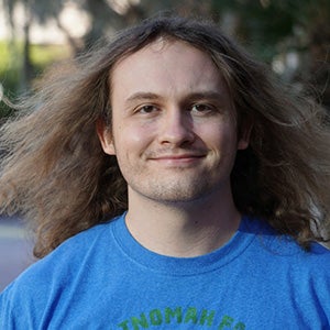 Portrait of man with long dirty blonde hair in blue T shirt